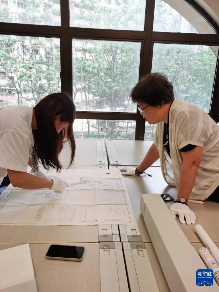 6月12日，東江縱隊(duì)老戰(zhàn)士劉克強(qiáng)的外孫女黎詩(shī)雅（左）與東江縱隊(duì)老戰(zhàn)士后人、香港抗戰(zhàn)史研究者王玉珍在香港歷史檔案大樓查閱史料。新華社發(fā)