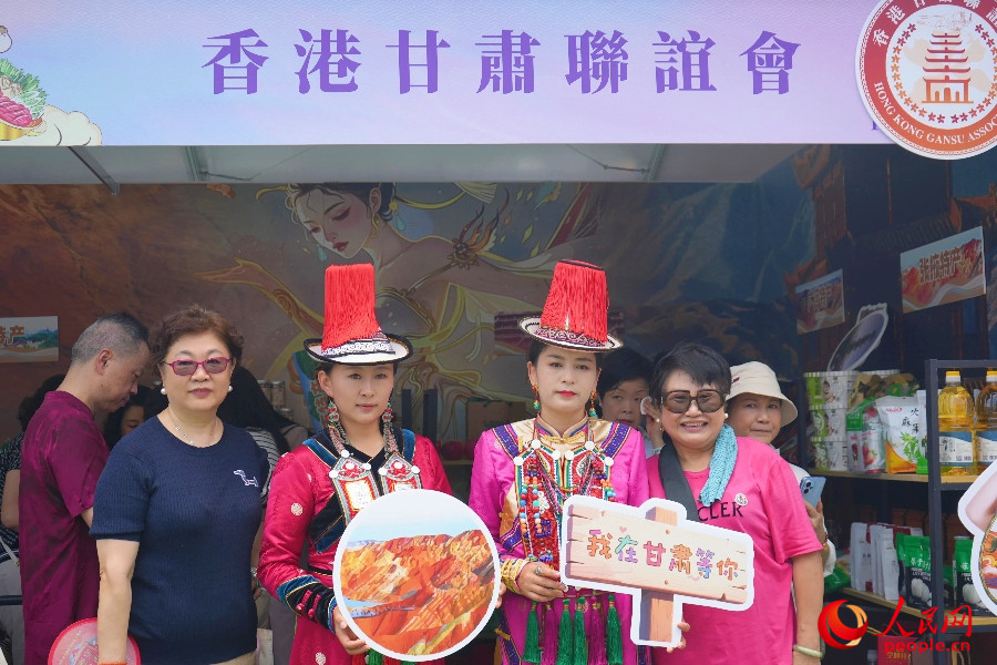 市民與身著民族服飾的工作人員合影。人民網 實習生王悅 攝
