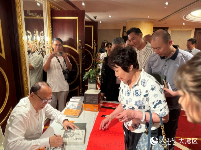 根據(jù)長(zhǎng)篇小說(shuō)《孤島》改編的抗戰(zhàn)題材電視劇投拍，激發(fā)了讀者對(duì)原著的閱讀興趣。圖為原著作者胡根為讀者簽名。人民網(wǎng)記者 富子梅攝