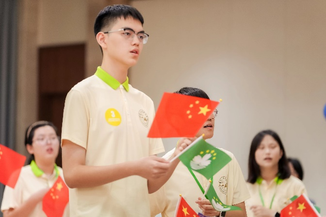 圖為同學(xué)們在聯(lián)歡會上揮舞國旗區(qū)旗唱響《我和我的祖國》。主辦方供圖