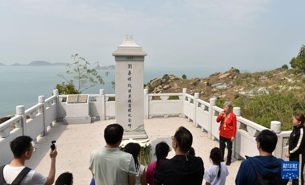 在香港新界屯門龍鼓灘的劉春祥抗日英雄群體紀(jì)念碑前，90歲的抗日老戰(zhàn)士林珍為人們講述中國共產(chǎn)黨領(lǐng)導(dǎo)下的東江縱隊(duì)港九獨(dú)立大隊(duì)的故事（2025年3月15日攝）。新華社記者 陳鐸 攝