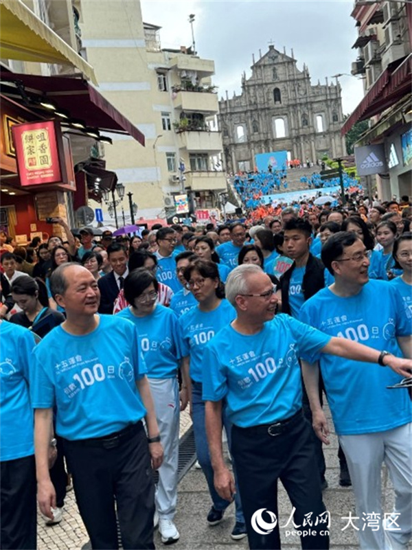 圖為岑浩輝身穿藍色運動背心，精神抖擻與眾人一同從大三巴牌坊起步，參與“迎百日 健步行”活動。人民網記者 富子梅攝