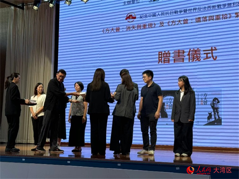 圖為馮雪松和趙香玲向澳門青年事務(wù)委員會委員等贈書。人民網(wǎng)記者 富子梅攝