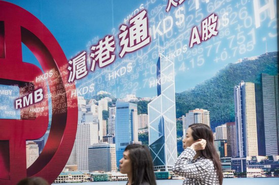 市民從香港中環(huán)一家銀行的滬港通廣告牌前走過。新華社記者呂小煒攝（資料照片）