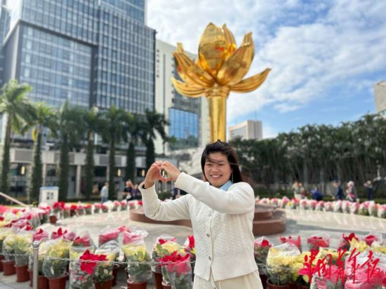 來自廣東的游客對著盛世蓮花雕塑“比心”，她說“比心”是因為想要表達自己“愛祖國、愛澳門”的心情。中青報·中青網(wǎng)記者 寧迪/攝