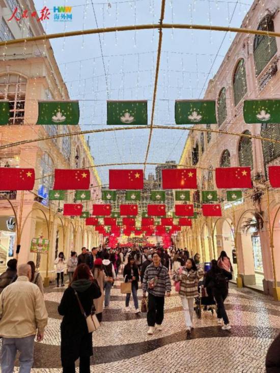 12月15日，在澳門街頭，鮮艷的五星紅旗和澳門特區(qū)區(qū)旗迎風飄揚。（海外網(wǎng) 牛寧 攝）
