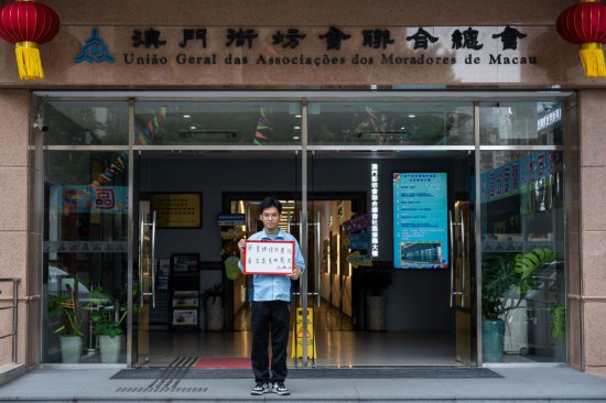 12月18日，澳門街坊會(huì)聯(lián)合總會(huì)的工作人員馮鴻俊在展示祝福語。