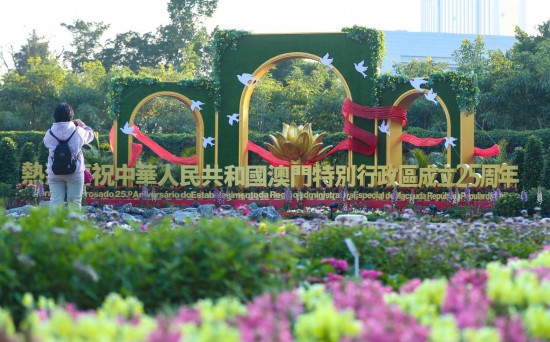 12月17日，市民在澳門一處慶祝花壇前拍照。新華社記者 姚琪琳 攝