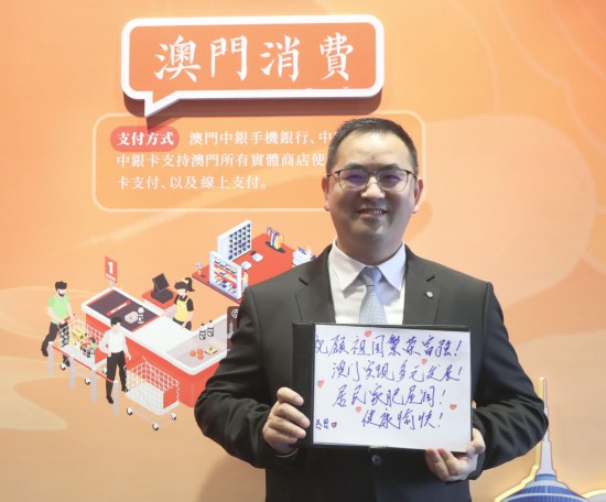 12月18日，澳門中銀員工王金思在展示祝福語。
