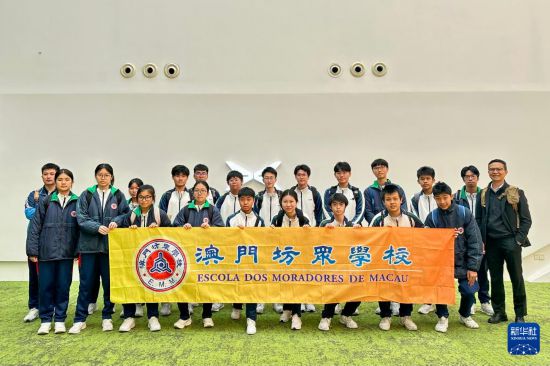 澳門坊眾學(xué)校學(xué)生在小鵬汽車廣州總部合影留念（3月21日攝）。新華社記者 郭雨祺 攝