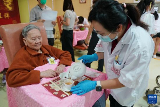5月24日，在香港松悅園耆和護養(yǎng)院，身穿白衫的伙計在“茶樓”售賣茶點，端茶倒水。新華社發(fā)（王申 攝）