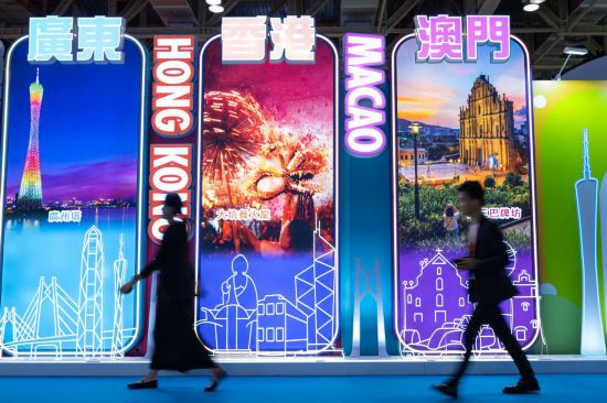4月25日，參觀者從第十三屆澳門國際旅游（產(chǎn)業(yè)）博覽會大灣區(qū)展板前經(jīng)過。新華社發(fā)（張金加攝）