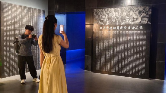 8月1日，采訪(fǎng)團(tuán)成員在常德博物館拍攝日軍常德細(xì)菌戰(zhàn)受害者名錄。新華社記者 馬欣然 攝