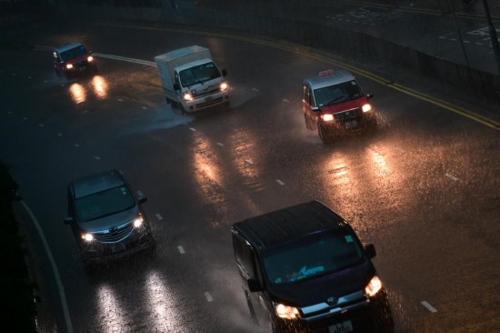 8月5日，車輛在香港街頭雨中行駛。新華社記者 朱煒 攝